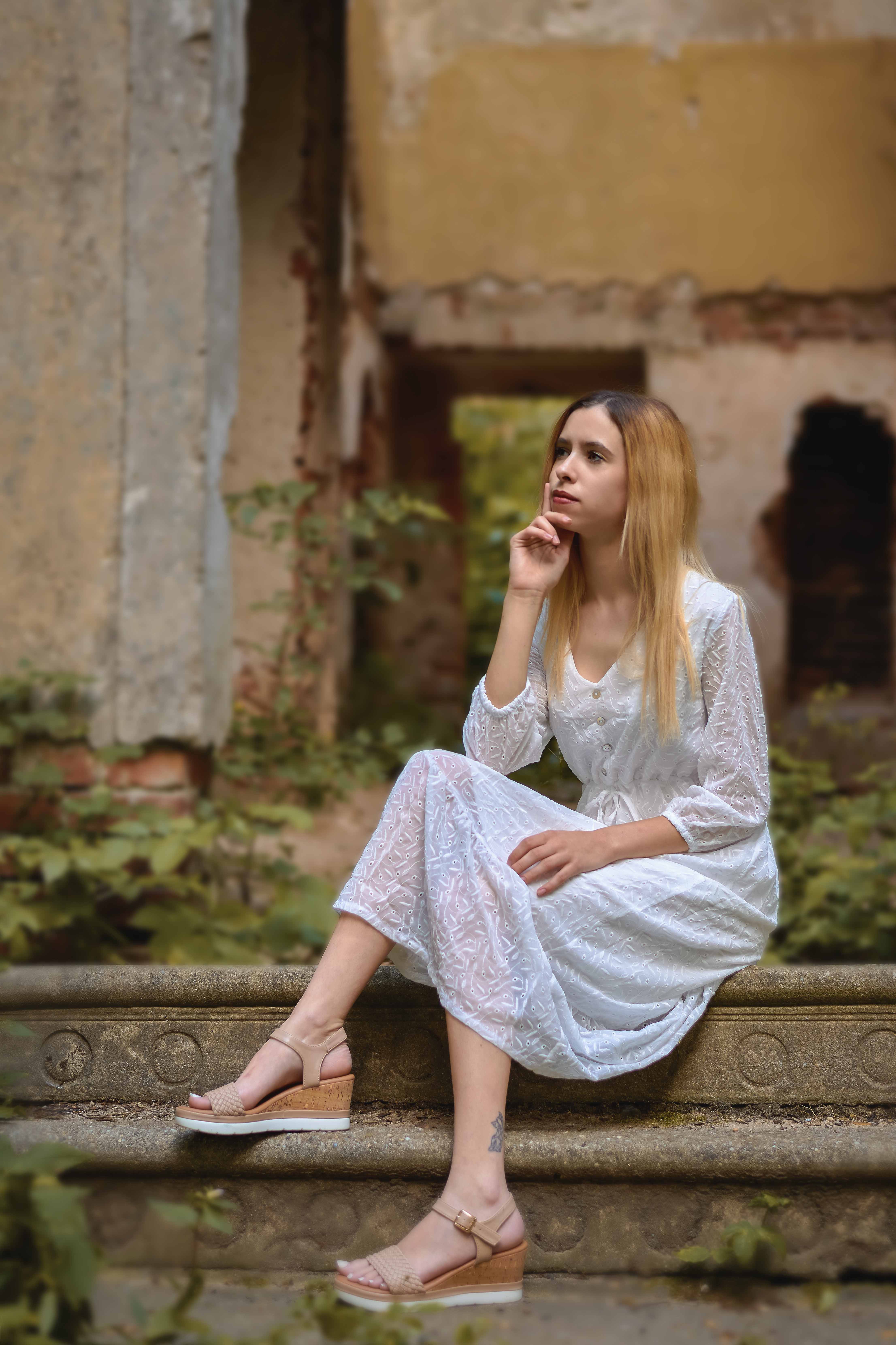 Kobieta w eleganckiej sukni podczas plenerowej sesji portretowej w wśród ruin